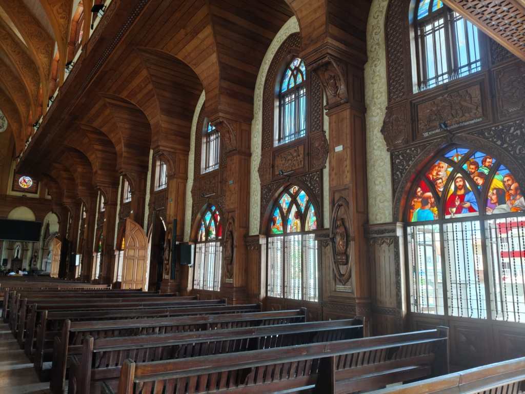 Woodwork and stained glass windows inside Vettucaud Church. 