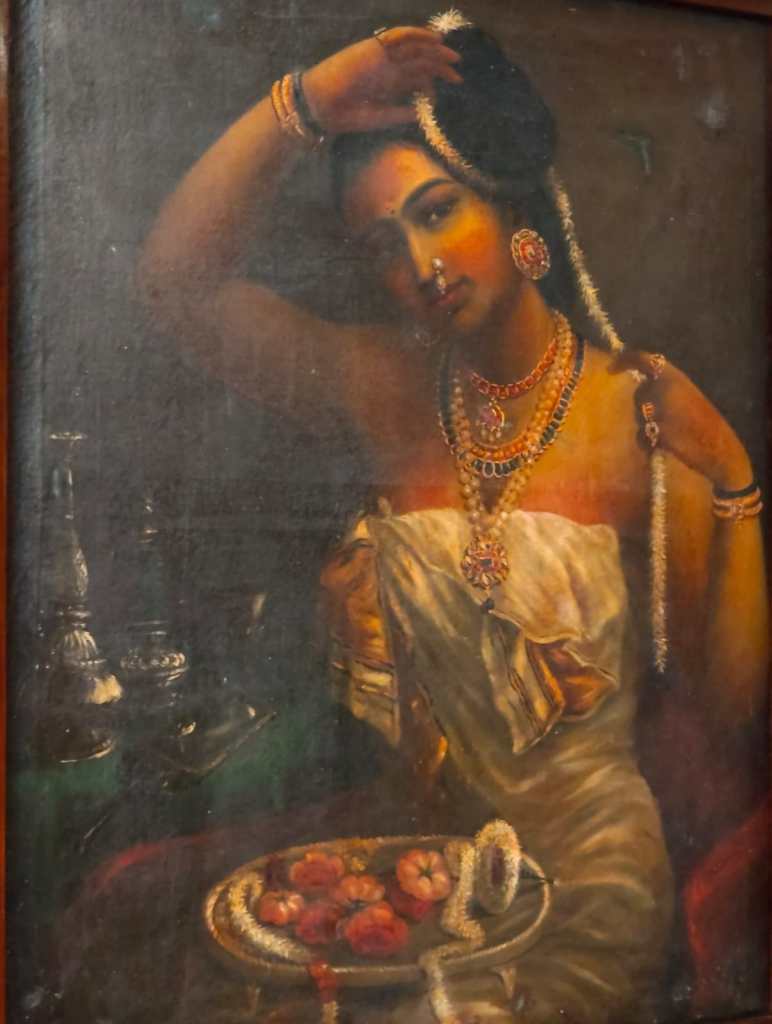 The painting 'Nair Lady Adorning Her Hair' by Ravi Varma. 
